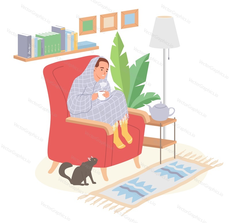 Мужчина согревается, завернувшись в одеяло, пьет чай или кофе из чашки, сидя в кресле над интерьером домашней гостиной с кошкой
